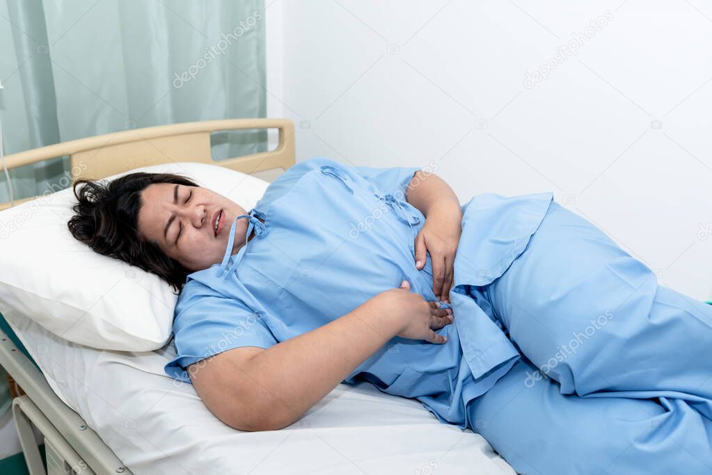 Asian fat woman patients lying in the  patient's bed, she had severe abdominal pain, From gastritis and enteritis, to people and health care concept.