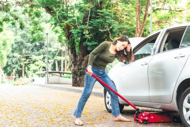 Asyalı çekici kadın, arabayı yalayarak lastiği değiştirmekten yoruldu. Bürokratik parkta, güçlü bir kadına ve ulaşım aracına..