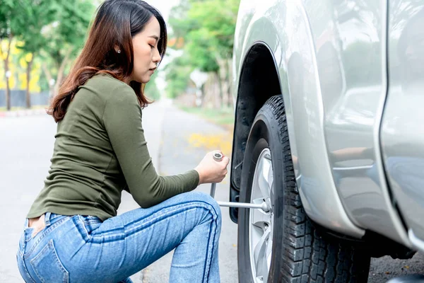 タイヤ交換のための装置であるレンチを使ったアジアの魅力的な女性ピックアップトラック道路だけで 強い女性と輸送コンセプトへ — ストック写真
