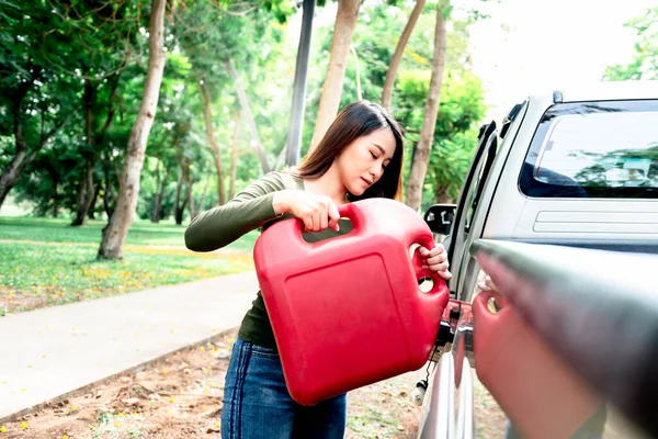 アジアの魅力的な女性は 石油タンクを保持ピックアップトラックを燃料を補給するために道端に駐車し 石油が旅の間に使い果たされたという事実のために 人々への旅行の概念の準備 — ストック写真