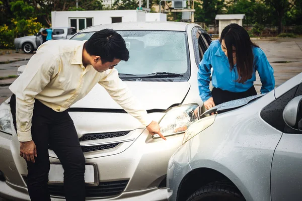 雨の中 自動車事故の被害を指摘するビジネスマンを見るアジアのビジネス女性は 人々と自動車保険の概念に — ストック写真