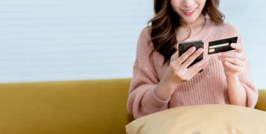 Asyalı çekici bir kadının cep telefonlarını internet üzerinden alışveriş yaparken, mutlu insanlara ve online alışveriş yaparken bulanık görüntüleri..