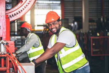 Afrikalı Amerikalı işçiler fabrikadaki endüstriyel makinelerin bakımını kontrol ediyorlar, endüstri konseptinde çalışan insanlara..