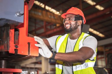 Afrikalı Amerikalı işçiler fabrikadaki endüstriyel makinelerin bakımını kontrol ediyorlar, endüstri konseptinde çalışan insanlara..