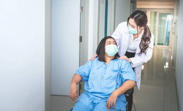 Woman doctor\'s hand rests on the shoulder of the female patient Which sat in a wheelchair to encourage And give patients confidence in receiving treatment, to health care and health insurance concept.