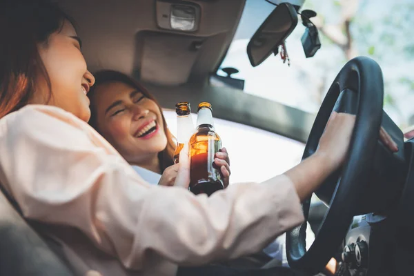 酒を飲んで酒を飲んで酒を飲むアジアの女性2人が運転しながら酒を飲むというコンセプトは 道路上の事故の原因です — ストック写真