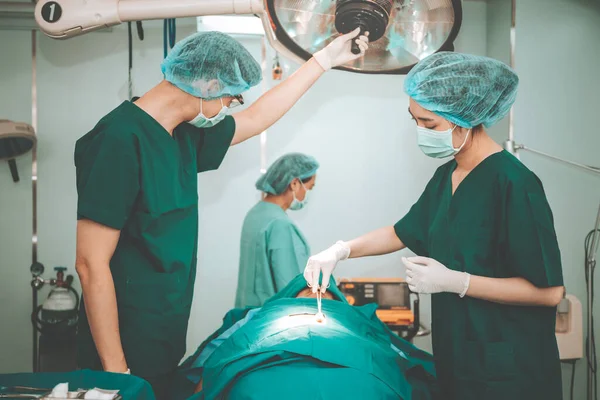 Asian doctor surgeon team,  Working in the operating room, Doing nose surgery on a female patients, to people health care and cosmetic surgery concept.