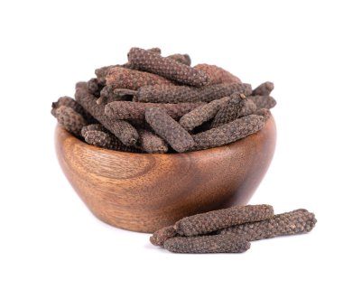 Ahşap kasede uzun biber, beyaz arka planda izole. Pippali yığını mı yoksa kavalcı mı?.