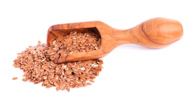 Tahta kepçe içinde kahverengi keten tohumu, beyaz arka planda izole. Kuru keten tohumu veya keten tohumu yığını.