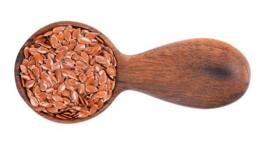 Tahta kaşıkta kahverengi keten tohumu, beyaz arka planda izole. Kuru keten tohumu veya keten tohumu yığını. Üst görünüm.