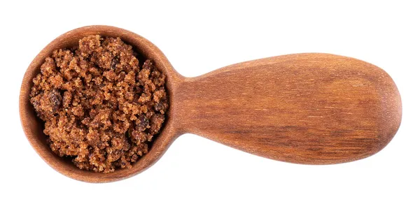 Muscovado cukor fából készült kanálban, fehér alapon elszigetelve. Barbados cukor, khandsari vagy khand. Felülnézet. — Stock Fotó