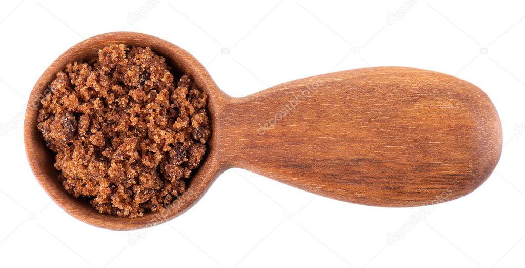 Muscovado sugar in wooden spoon, isolated on white background. Barbados sugar, khandsari or khand. Top view.
