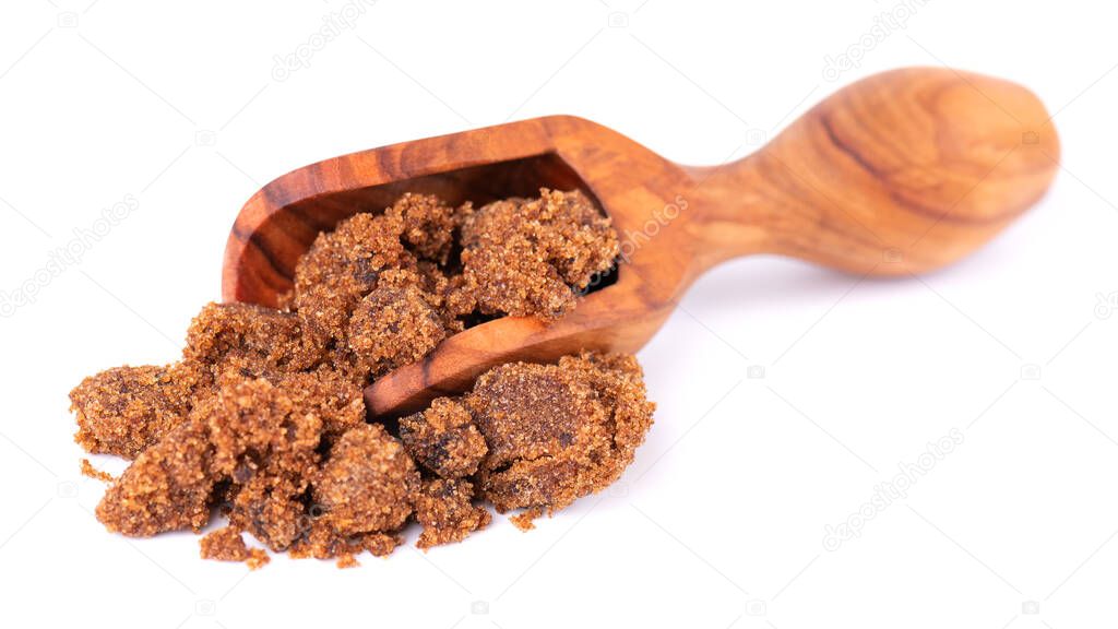 Muscovado sugar in wooden scoop, isolated on white background. Barbados sugar, khandsari or khand.