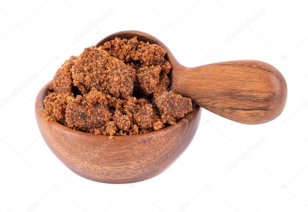 Muscovado sugar in wooden bowl and spoon, isolated on white background. Barbados sugar, khandsari or khand