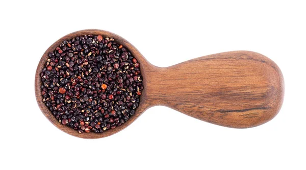 Svart quinoa frön i trä sked, isolerad på vit bakgrund. Högen med rå kinwa. Ovanifrån. — Stockfoto