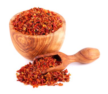 Kırmızı kırmızı biber taneleri zeytin kabında ve kepçeyle kaplanmış, beyaz arka planda izole edilmiş. Baharatlar ve bitkiler