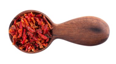 Tahta kaşıkta kırmızı biber taneleri, beyaz arka planda izole edilmiş. Baharatlar ve bitkiler. Üst görünüm