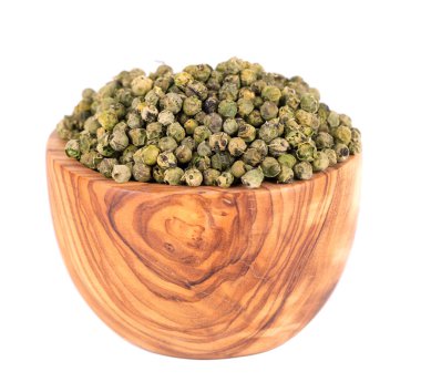 Yeşil biberler zeytin kasesi ve kaşıkta, beyaz arka planda izole edilmiş. Kuru yeşil biber taneciği. Organik baharat