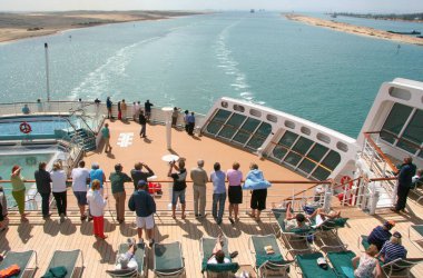 Passengers on the stern of a cruise ship sailing on the Suez Canal