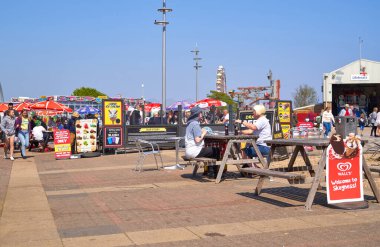 İnsanlar Skegness, İngiltere 'de bir açık hava fast food mağazasında yemek yiyorlar.                               