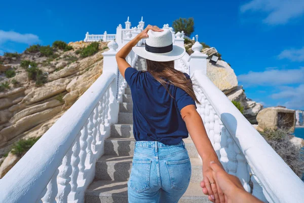 Giovane turista in cappello bianco che conduce l'uomo a mano. Seguitemi. Balcon del Mediterraneo, Benidorm, Spagna. Coppia in vacanza estiva — Foto Stock