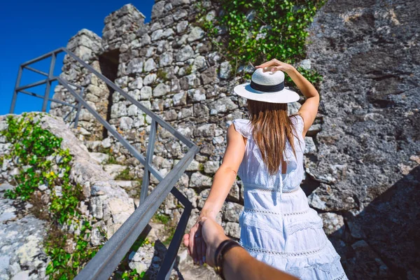 Donna turistica spensierata in abito bianco e cappello da sole che porta il suo ragazzo. Seguitemi. Coppia in vacanza in Sintra, Portogallo — Foto Stock