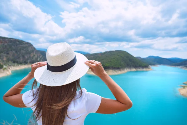 Mulher turista em roupas brancas e chapéu de sol desfrutando da natureza e ótima vista do lago com água azul pura na Espanha. Férias de verão na reserva natural — Fotografia de Stock
