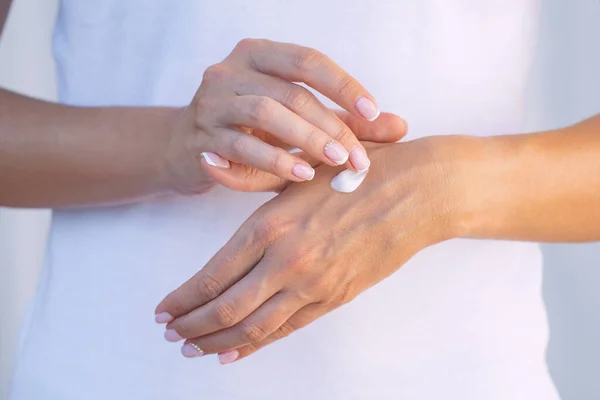 Mujer que aplica crema hidratante en sus manos secas. Crema de manos. Protección de la piel. Cuidado de manos o concepto de cuidado de la piel — Foto de Stock