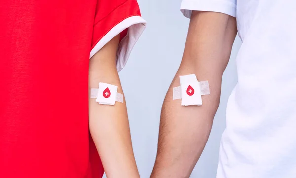 Doação de sangue. Homem e mulher doadores de sangue com bandagem depois de dar sangue. Salve vidas. Conceito mundial do dia do doador de sangue — Fotografia de Stock
