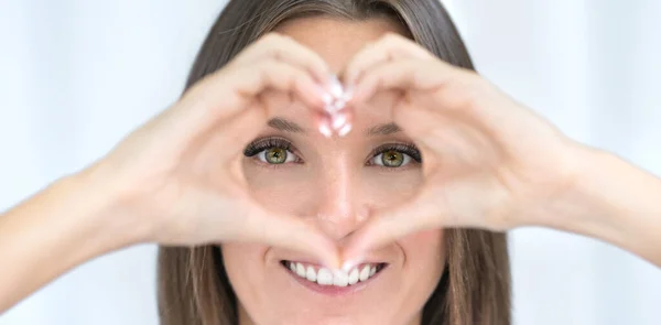 Augenpflege. Gesunde Augen. Junge Frau mit perfektem Sehvermögen formt Herz mit Händen. Augenheilkunde-Konzept — Stockfoto