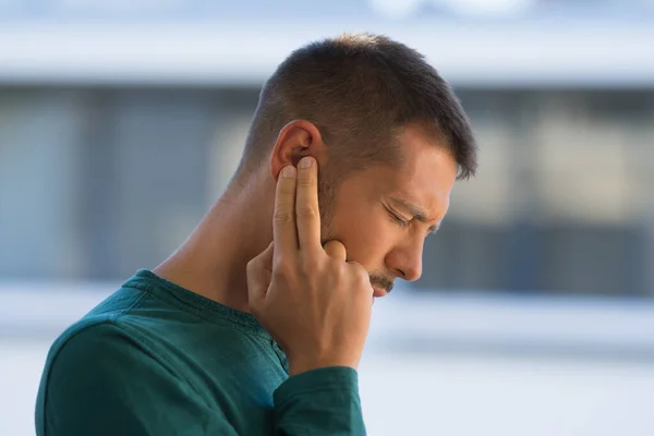 En man med tinnitus. Man rör vid örat på grund av stark öronvärk eller öronvärk. Otit — Stockfoto