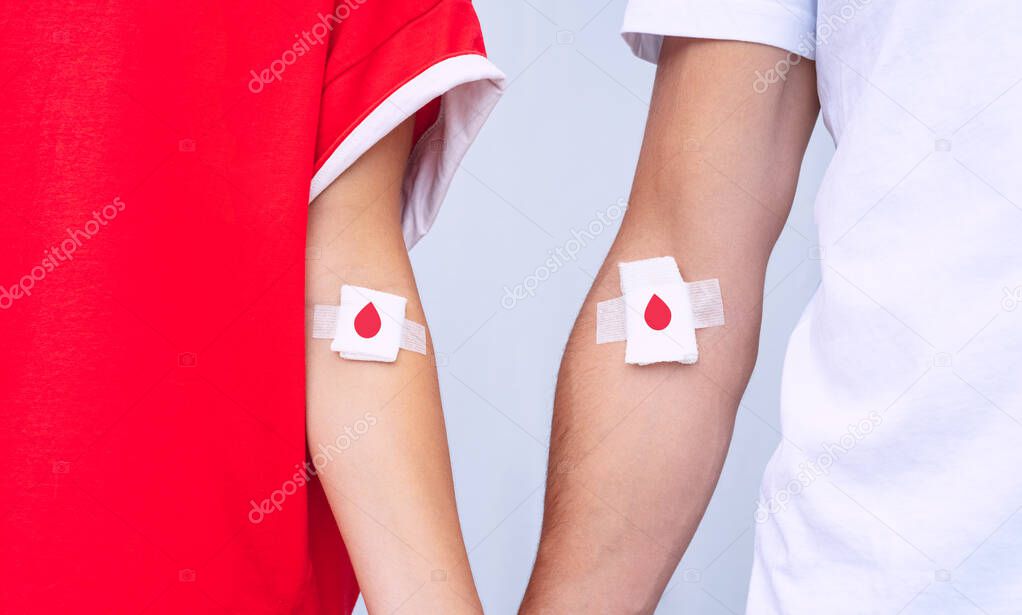 Giving blood saves lives. Blood donation. Man and woman blood donors with bandage