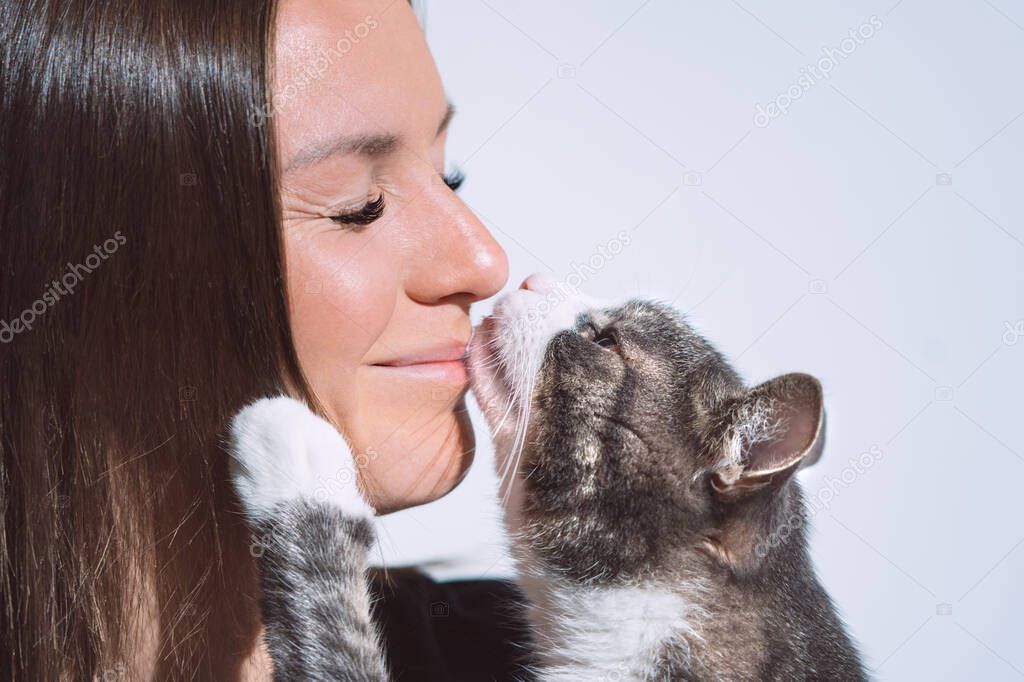 Cute cat kissing womans nose. Pets love, friendship, trust and lifestyle concept.