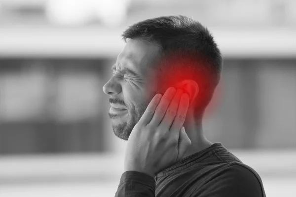 Young man suffering from of strong earache or ear pain. Ear diseases — Stockfoto