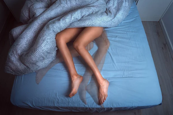 Woman sleeping in the bed and suffering from RLS or restless legs syndrome — стоковое фото