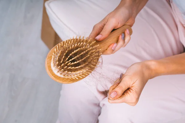 Mujer quitándose el pelo del cepillo. Problema de pérdida de cabello. Cabello malo cayendo — Foto de Stock