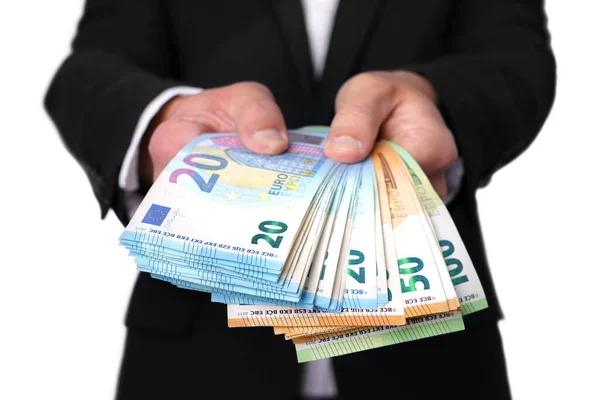 Um homem que dá ou oferece dinheiro. Empresário detentor de notas de euro ou numerário isolado sobre fundo branco — Fotografia de Stock