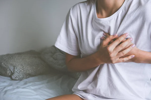 Mujer sosteniendo el pecho debido a una enfermedad cardíaca, ataque al corazón, dolor cardíaco o dolor en el pecho —  Fotos de Stock