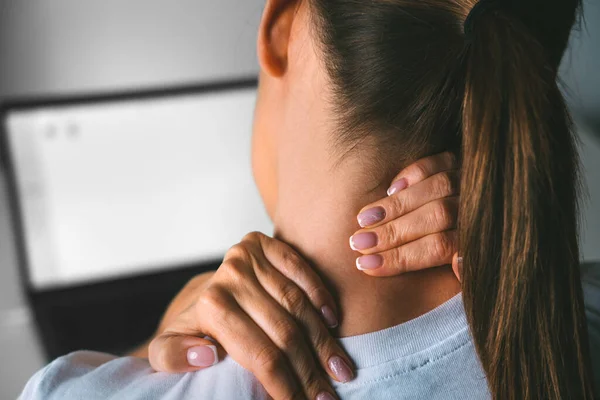 Νεαρή γυναίκα που πάσχει από πόνο στον αυχένα μετά την εργασία στον υπολογιστή και μασάζ στο λαιμό για την ανακούφιση του πόνου — Φωτογραφία Αρχείου
