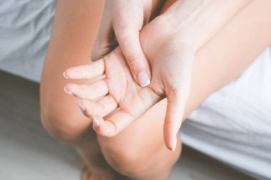 El ağrısı ya da parmak ağrısı çeken bir kadın. Uykudan sonra el uyuşması ya da uzuv uyuşukluğu. Acıtan bir el masajı.
