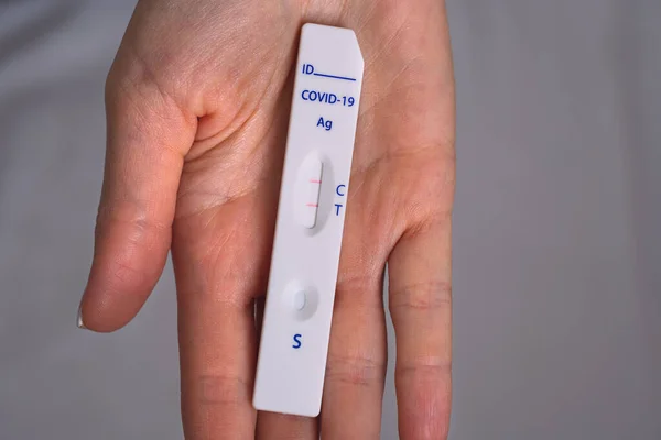 Mulher mão segurando teste rápido antígeno vívido ou teste vívido expresso com resultado positivo covid-19 — Fotografia de Stock