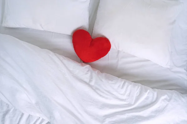 Vista superior de la cama blanca con almohadas y leer juguete corazón — Foto de Stock