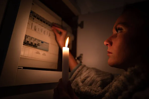 停電や停電時に家庭でヒューズボックスをチェックする女性。電気の概念なし — ストック写真