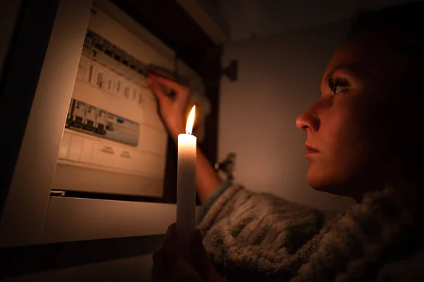 Mulher verificando fusível caixa em casa durante a falta de energia ou apagão. Sem conceito de eletricidade — Fotografia de Stock