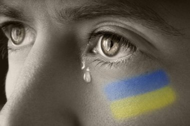 Ukrayna bayrağı taşıyan adam ağlıyor. Rusya ve Ukrayna savaşı. Ukrayna 'yı kurtar ve savaşı durdur.