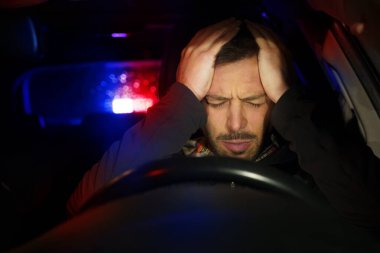 Kırmızı ve mavi ışıkları yanıp sönen ve siren çalan polis arabası adam sürücüsünü durdurdu. Trafik kurallarının ihlali