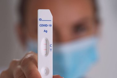Pozitif koronavirüsle birlikte ekspres covid testi yapan bir kadın.
