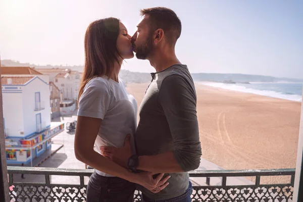 Молода пара цілується на балконі. Пара закохалася, проводячи свято разом — стокове фото