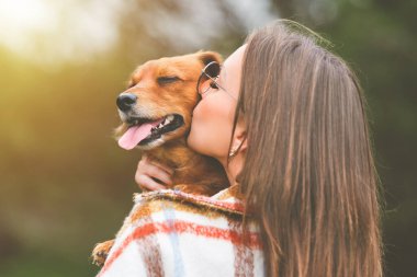 Öpüşen kadın köpek. Köpek ve sahibi açık havada birlikte. Hayvanlar için aşk