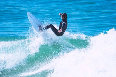Surfer making trick on the wave on shortboard. Man catching waves in ocean. Water sports activity